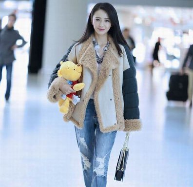机场玩时尚 佟丽娅怀抱“小萌熊”